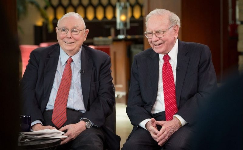 Munger và Buffett cùng đeo cà vạt đỏ, cười trong một buổi phỏng vấn truyền hình